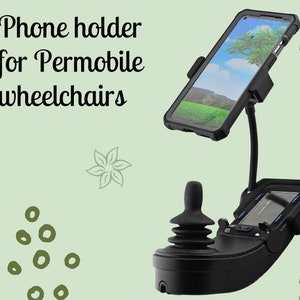 May include: A black phone holder with a flexible arm attached to a black joystick. The phone holder is designed to fit a smartphone with a case. The phone holder is mounted on a black base. The phone holder is designed for use with Permobile wheelchairs.