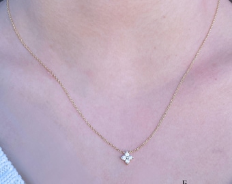 May include: A delicate gold chain necklace with a small, sparkling diamond flower pendant.