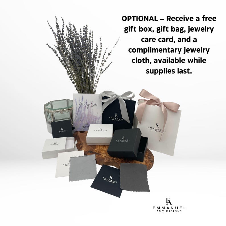 May include: A collection of jewelry packaging including black and white gift boxes, a white gift bag with a pink ribbon, a gray jewelry cloth, and a care card. The text reads: OPTIONAL &ndash; Receive a free gift box, gift bag, jewelry care card, and a complimentary jewelry cloth, available while supplies last. EMMANUEL AMY DESIGNS.