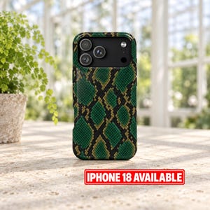 Peut inclure: Une coque de smartphone avec un motif peau de serpent vert et noir à l'aspect texturé. La coque présente un module photo noir avec trois objectifs circulaires et un flash. Une étiquette rectangulaire rouge affiche le texte IPHONE 18 AVAILABLE.