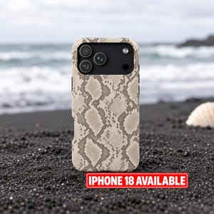 May include: A smartphone case featuring a beige and brown snakeskin pattern with a black camera module cutout. The case displays the text IPHONE 18 AVAILABLE in a red rectangular box at the bottom, indicating compatibility for the device.