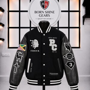 May include: A black varsity jacket with white striped ribbed trim on the collar, cuffs, and hem. The jacket features various embroidered patches, including a flag, a goat, a cross, an owl, and the text "FIFTY BITTY", "PC", "COACH B.", and "TOUCHDOWN".