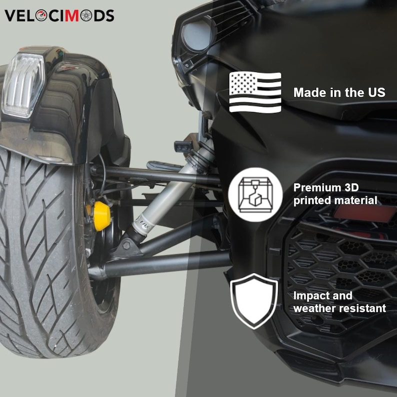 K&ouml;nnte beinhalten: Schwarze Fahrzeugkomponente mit Reifen, Federung und Karosserieteilen. Merkmale sind "Made in the US", "Premium 3D printed material" und "Impact and weather resistant". Das Logo "VELOCIMODS" befindet sich oben links.