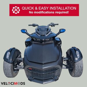 Puede incluir: Una motocicleta negra de tres ruedas con espejos laterales azules. La parte delantera del veh&iacute;culo tiene una rejilla de panal y el texto "VELOCIMODS" est&aacute; en la parte inferior. Encima de la motocicleta hay una pancarta roja con el texto "QUICK & EASY INSTALLATION" y "No modifications required!"