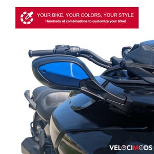 Puede incluir: Primer plano de un trike negro con espejos laterales azules. El texto "YOUR BIKE, YOUR COLORS, YOUR STYLE" se muestra encima del trike. Tambi&eacute;n se muestra el texto "Hundreds of combinations to customize your trike!". La marca "VELOCIMODS" se muestra en la parte inferior.