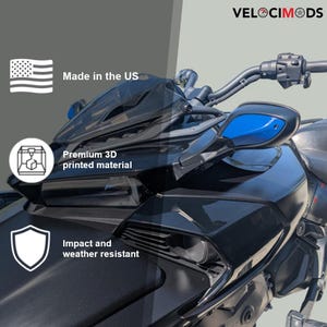 Puede incluir: Primer plano de una motocicleta negra con espejos laterales azules. La imagen incluye el texto "VELOCIMODS", "Made in the US", "Premium 3D printed material" y "Impact and weather resistant".