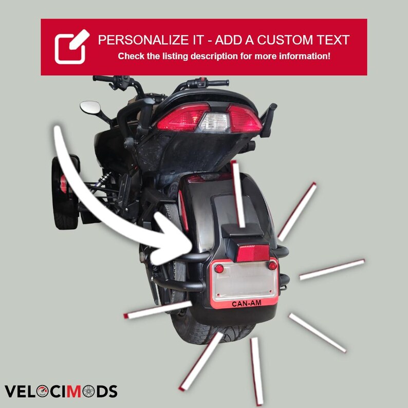 K&ouml;nnte beinhalten: Schwarzes und rotes Can-Am Dreiradmotorrad mit dem Text "PERSONALIZE IT - ADD A CUSTOM TEXT" in einem roten Banner. Das Bild enth&auml;lt auch den Text "Weitere Informationen finden Sie in der Angebotsbeschreibung!" und "VELOCIMODS".