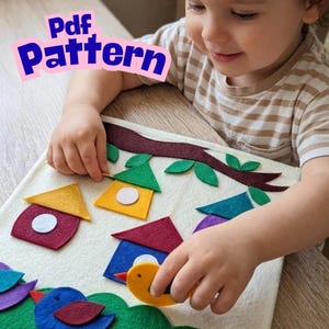Peut inclure: Un tableau d'activité en feutrine avec une branche d'arbre marron, des feuilles vertes et des nichoirs colorés avec des accents circulaires blancs. Plusieurs oiseaux en feutrine bleus, jaunes et rouges sont sur une base verte. Texte Pdf Pattern.