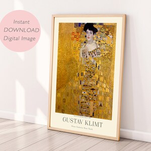 May include: A digital print of a painting by Gustav Klimt, featuring a woman in a gold dress with a black hat. The background is a mosaic of gold, white, and black geometric shapes. The text "Gustav Klimt" and "Neue Galerie New York" is at the bottom of the print.