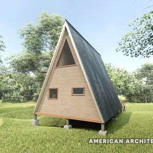 May include: A wooden A-frame cabin with a gray metal roof. The cabin has two windows and a dormer window. The cabin is on a foundation of concrete blocks and is surrounded by green grass.