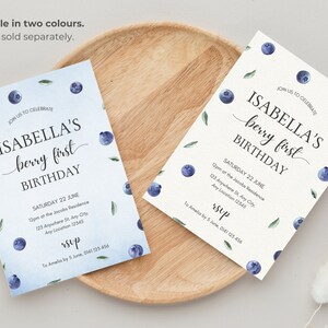May include: Two printable invitations for a first birthday party. The invitations feature a watercolor design with blueberries and leaves. The text on the invitations reads "Join us to celebrate Isabella's berry first birthday" and includes the date, time, and location of the party. The invitations also include the text "RSVP" and contact information.