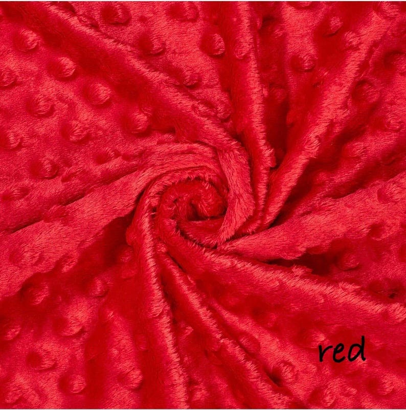 May include: Close-up of a vibrant red fabric with a textured, dotted pattern. The plush material is gathered and swirled, creating a dynamic display of light and shadow. The word "red" is written in a cursive font in the bottom right corner.