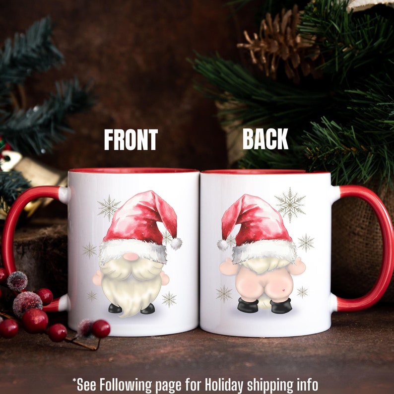 May include: Two white coffee mugs with red rims. The mug on the left has a cartoon image of a gnome with a red hat and white beard. The mug on the right has a cartoon image of a gnome with a red hat and white beard, but the gnome is facing away from the viewer and is showing its backside. The text 'FRONT' is above the mug on the left and the text 'BACK' is above the mug on the right. The text '*See Following page for Holiday shipping info' is below the mugs.
