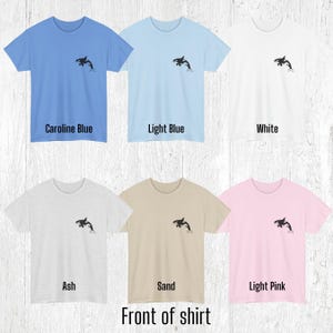 Various color shirts showing small black Orca design on the front.