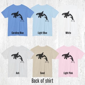 Various color shirts showing large black Orca design on back.