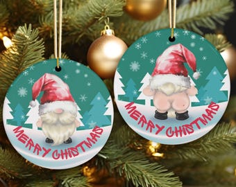 Könnte beinhalten: Zwei runde Weihnachtsschmuckstücke mit einem tealfarbenen Hintergrund, der einen Zwerg mit roter Mütze und schwarzen Schuhen zeigt. Die Ornamente tragen die Worte "MERRY CHRISTMAS" in Rot und Weiß. Schneeflocken und Bäume sind ebenfalls zu sehen.