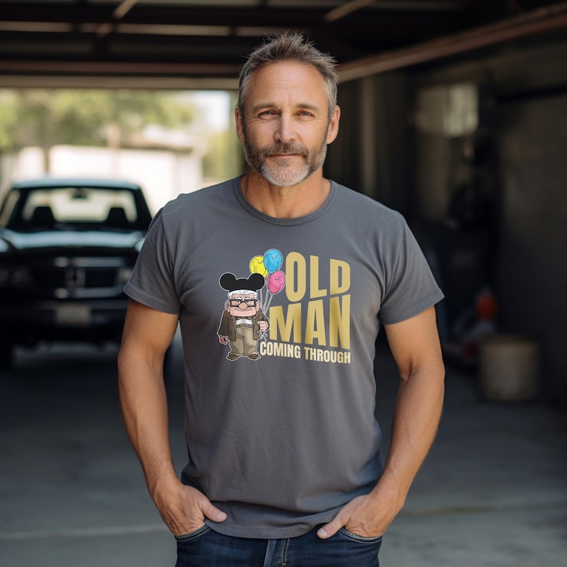 May include: A gray t-shirt with a cartoon character holding balloons and the text "Old Man Coming Through".