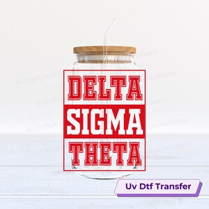 May include: A clear glass jar with a wooden lid and a straw. The jar displays the words "DELTA SIGMA THETA" in bold red letters. The text "Uv Dtf Transfer" is at the bottom.