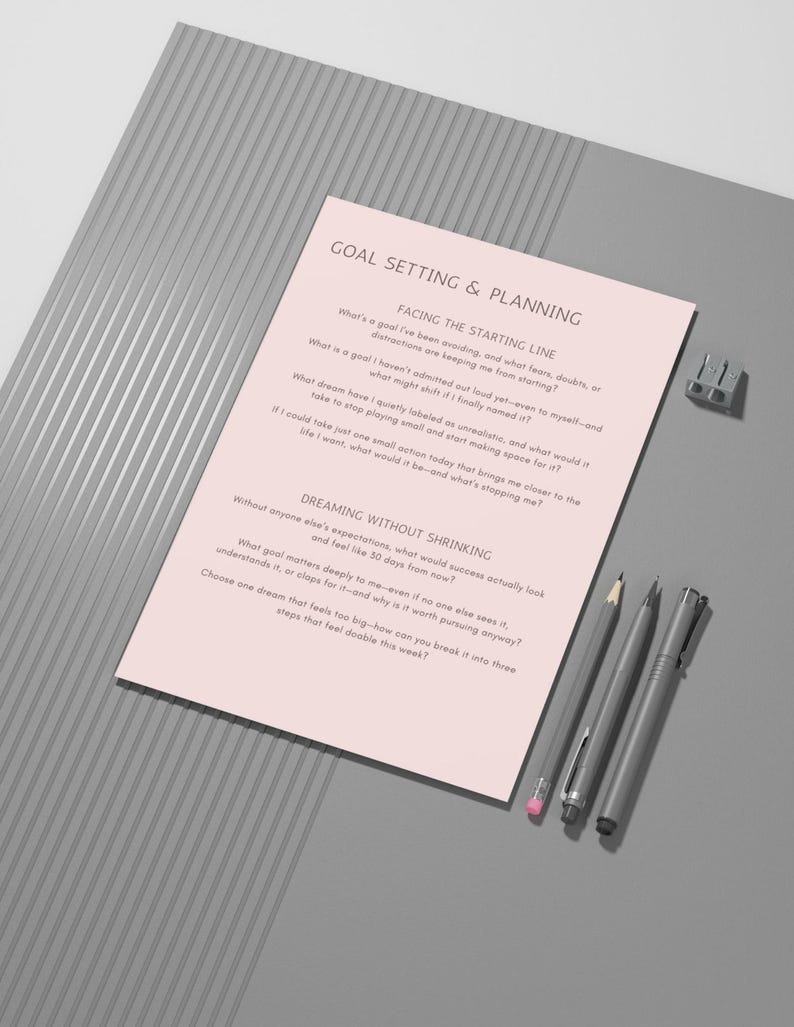 Op de afbeelding: Een roze werkblad voor doelstelling en planning met tekst, een potlood, twee pennen en een puntenslijper op een grijze ondergrond. Het werkblad bevat vragen voor zelfreflectie en doelstelling.