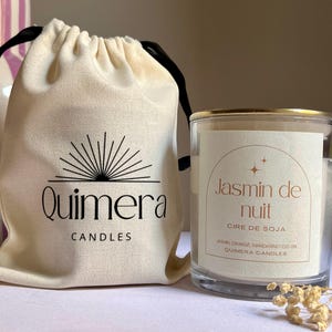 Pode incluir: Um frasco de vela de vidro transparente com uma borda dourada e um r&oacute;tulo que diz "Jasmin de nuit". Ao lado, uma bolsa com cord&atilde;o creme com o logotipo "Quimera Candles". A vela &eacute; preenchida com cera e a bolsa &eacute; de lona.