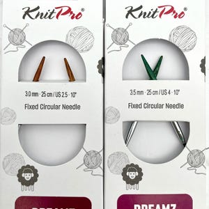 May include: Two packages of Knit Pro Dreamz fixed circular knitting needles. One package shows 3.0 mm needles, 25 cm (9.8 inches) long, US size 2.5-10. The other package shows 3.5 mm needles, 25 cm (9.8 inches) long, US size 4-10. Each package has the text "Fixed Circular Needle".