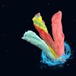 May include: Three colorful candy twists, one blue, one pink, and one rainbow, are swirling in a blue vortex against a black background with white stars.