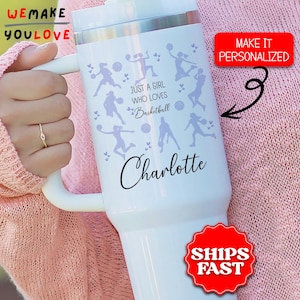 May include: White insulated tumbler with a handle, featuring a basketball theme. The design includes basketball player silhouettes and the text "Just a girl who loves Basketball" and the name "Charlotte".