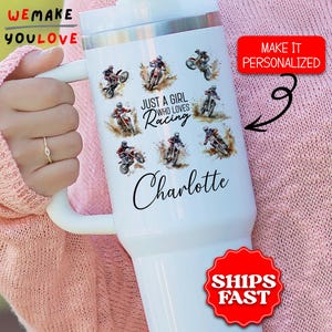 May include: White insulated tumbler featuring motocross racers in action. The tumbler has the text "Just a girl who loves racing" and a personalized name. A red sticker says "Make it personalized".