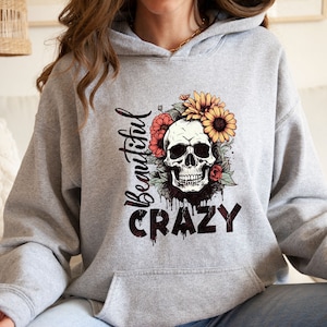 May include: Gray hoodie with a skull wearing a flower crown and the text "Beautiful Crazy".