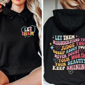 May include: Black hooded sweatshirt with a colorful graphic print that says "Let them misunderstand you, judge you, gossip about you, never doubt your worth! Your beauty! Keep shining!"