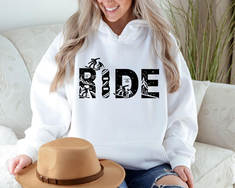 May include: White hoodie with the word "RIDE" in large black letters. The letters are designed with snowboarders and a snowboard. The hoodie is a comfortable, casual style.