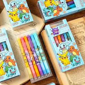 May include: A set of twelve colorful gel pens packaged in light blue boxes featuring illustrations of Pikachu, Squirtle, Charmander, and Bulbasaur. Each box is labeled with the text 12PCS, NO:A239, and PAKEN MNN, showcasing various character designs.
