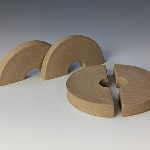 Peut inclure: Trois objets semi-circulaires beiges et un objet circulaire beige divisé en deux parties. Les objets ont une surface texturée et un design incurvé. Les objets sont disposés sur une surface blanche.