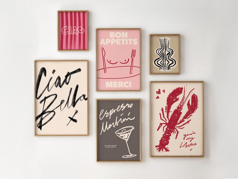 K&ouml;nnte beinhalten: Eine Sammlung gerahmter Kunstdrucke mit verschiedenen Designs. Die Drucke enthalten Texte wie "Ciao Bella" und "Bon App&eacute;tits" sowie Illustrationen von Hummer, Martiniglas und abstrakten Formen. Die Rahmen haben eine goldene Oberfl&auml;che.