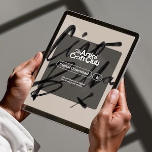 K&ouml;nnte beinhalten: Ein digitales Tablet, das einen digitalen Download vom The Artini Craft Club anzeigt. Der Bildschirm zeigt ein dunkelgraues Rechteck mit wei&szlig;em Text und einem Pfeil nach unten. Das Tablet wird von zwei H&auml;nden vor einem neutralen Hintergrund gehalten.