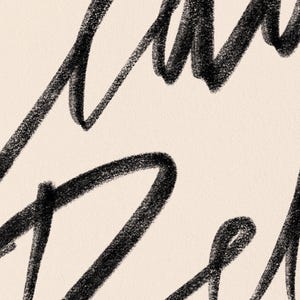 K&ouml;nnte beinhalten: Nahaufnahme eines cremefarbenen Hintergrunds mit schwarzer Handschrift. Die Schrift scheint ein Wort oder eine Phrase zu sein, mit dicken, strukturierten Strichen. Die Gesamt&auml;sthetik ist k&uuml;nstlerisch und minimalistisch, geeignet f&uuml;r Wandkunst oder Schreibwaren.