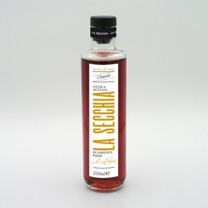 May include: A clear glass bottle filled with red liquid, labeled "LA SECCHIA" in gold lettering. The label also includes "Aceto di vino Chianti" and "ANTICA ACETAIA". The bottle has a black cap and contains 250ml of liquid.