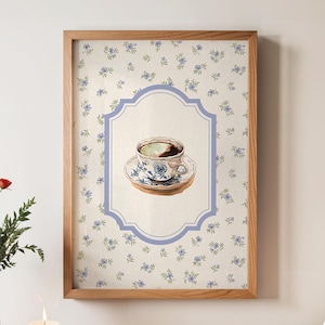 May include: A framed print featuring a watercolor illustration of a teacup and saucer. The teacup and saucer have a blue floral design. The background is a cream color with blue floral accents. The frame is made of wood.