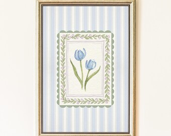 Puede incluir: Impresión en acuarela enmarcada con dos tulipanes azules. La obra de arte está sobre un fondo a rayas azul claro y blanco, con un borde decorativo verde y blanco. El marco tiene un acabado dorado, añadiendo un toque de elegancia al arte floral.