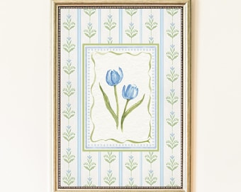 Puede incluir: Pintura en acuarela enmarcada con dos tulipanes azules con tallos y hojas verdes. La obra de arte está sobre un fondo a rayas azul claro y blanco con un borde decorativo, todo dentro de un marco dorado.