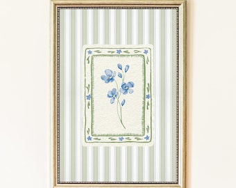Puede incluir: Obra de arte enmarcada con un diseño floral en acuarela. La obra presenta una imagen rectangular central de flores azules con tallos y hojas verdes, enmarcada por un borde verde con acentos en forma de estrella. El fondo tiene rayas verticales en verde claro y blanco.