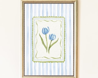 Puede incluir: Impresión en acuarela enmarcada con dos tulipanes azules con tallos y hojas verdes. La obra de arte está sobre un fondo a rayas azul claro y blanco, enmarcada en dorado. El borde interior es un diseño verde festoneado.