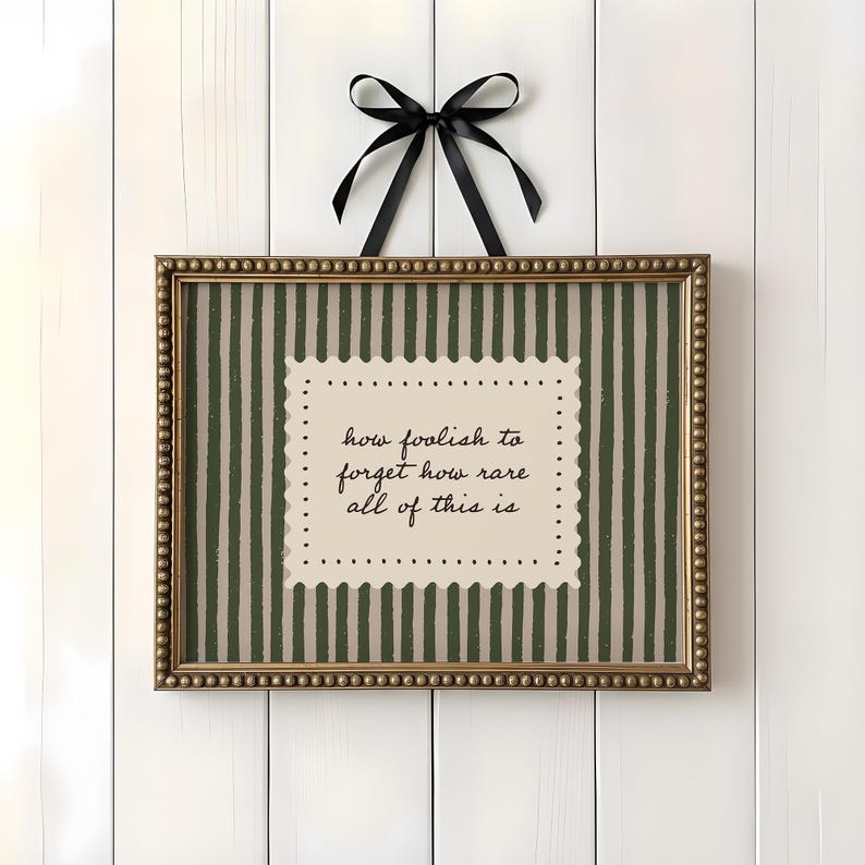 Olive green stripe quote wall art with scalloped vintage label and handwritten typography reading how foolish to forget how rare all of this is