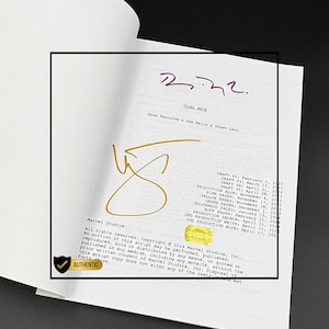 Op de afbeelding: Een open boek met een script getiteld "Tidal Wave" en handtekeningen in paarse en gouden inkt. Het script is gemarkeerd als "Authentic" door Marvel Studios, met copyright- en productiedetails.