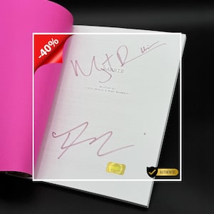 May include: A script for the movie "Barbie" with handwritten signatures in pink ink. The script is open, revealing the title and the names of the writers. A pink cover is visible on the left, and a "-40%" sticker is in the corner.