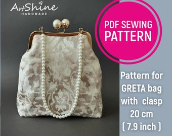 May include: A white and gold patterned fabric clutch bag with a gold clasp and a pearl chain strap. The bag is 7.9 inches wide. PDF Sewing Pattern for Greta bag with clasp.
