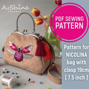 Può includere: Modello di cucito PDF per una borsa Nicolina con una chiusura a scatto da 19 cm. La borsa è marrone con un ricamo di coccinella rossa e un fiocco rosso.