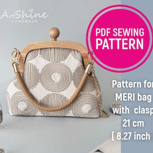 May include: A handmade Meri bag pattern with a clasp. The bag features a wooden frame and handle, with a beige and white patterned fabric. The bag is 8.27 inches (21 cm) wide. The image also includes the text "PDF SEWING PATTERN".