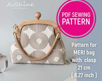 May include: A handmade Meri bag pattern with a clasp. The bag features a wooden frame and handle, with a beige and white patterned fabric. The bag is 8.27 inches (21 cm) wide. The image also includes the text "PDF SEWING PATTERN".