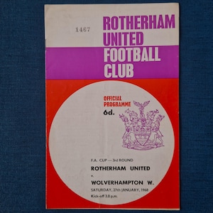 May include: A vintage football programme for Rotherham United Football Club. The cover features a purple and red design with the club's name. Details include the F.A. Cup 3rd Round match between Rotherham United and Wolverhampton W., played on Saturday, 27th January 1968.